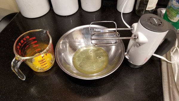 Yolks in measuring cup, whites in bowl, with electric mixer