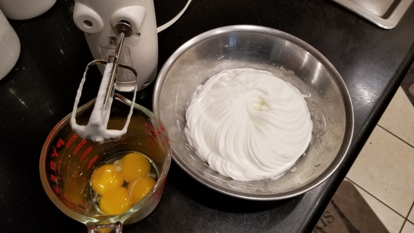 Four yolks in measuring cup. Beaten whites in bowl