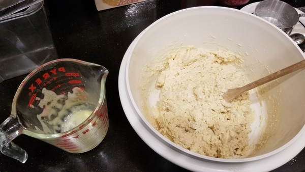 Bowl with ingredients. Empty measuring cup.